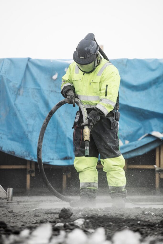 pexels-photo-13474086 Construction worker operating heavy machinery at a building site, ensuring safety and precision.